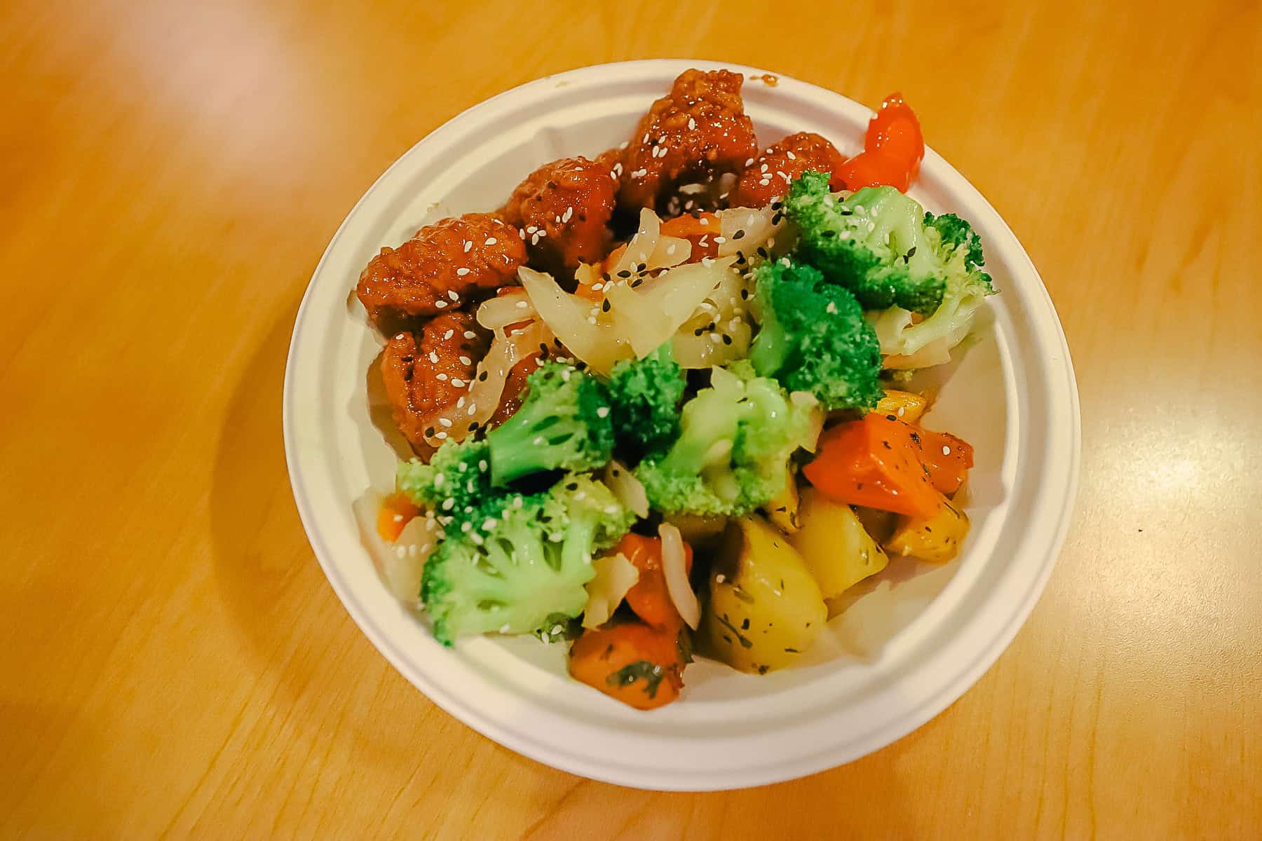 a meal with veggies and sesame chicken from the food court at Pop Century 