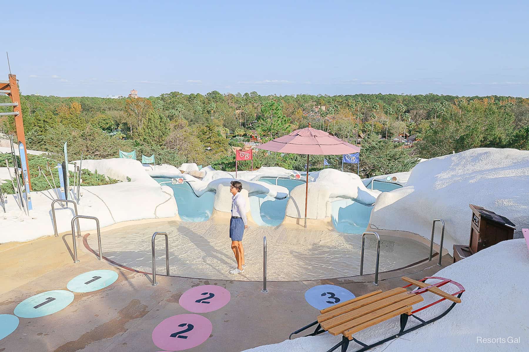 a cast member in a wading pool at the top of the Snow Stormers slides 