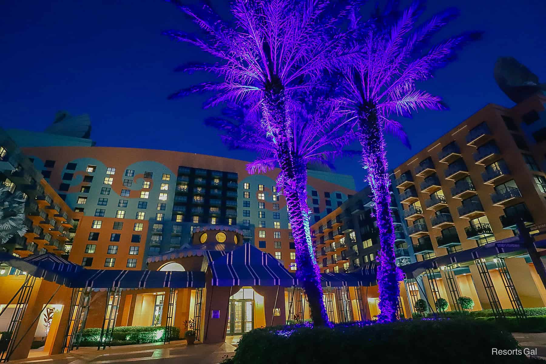 a cluster of palm trees with purple lights at the Disney Swan Hotel 