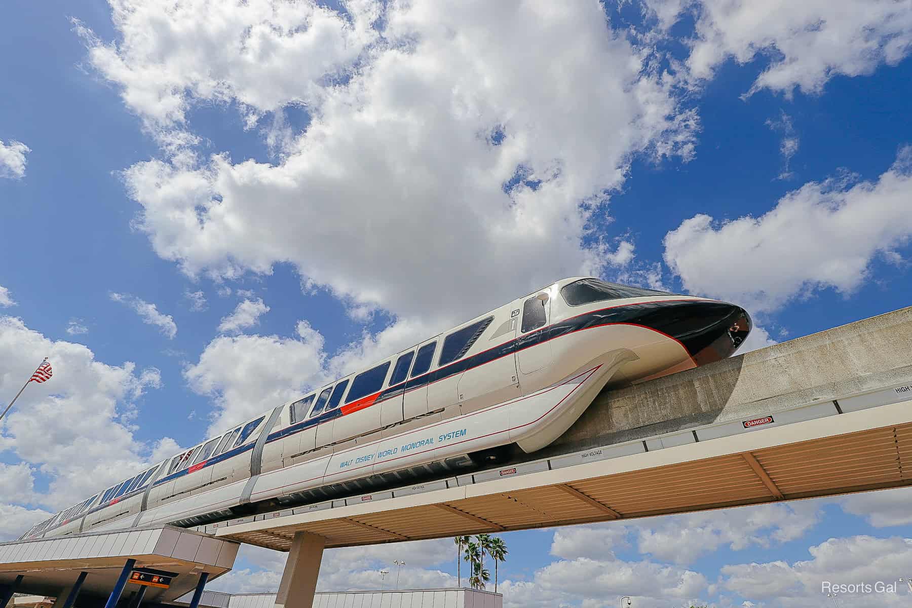 a black monorail with red stripes and blue sky backdrop 