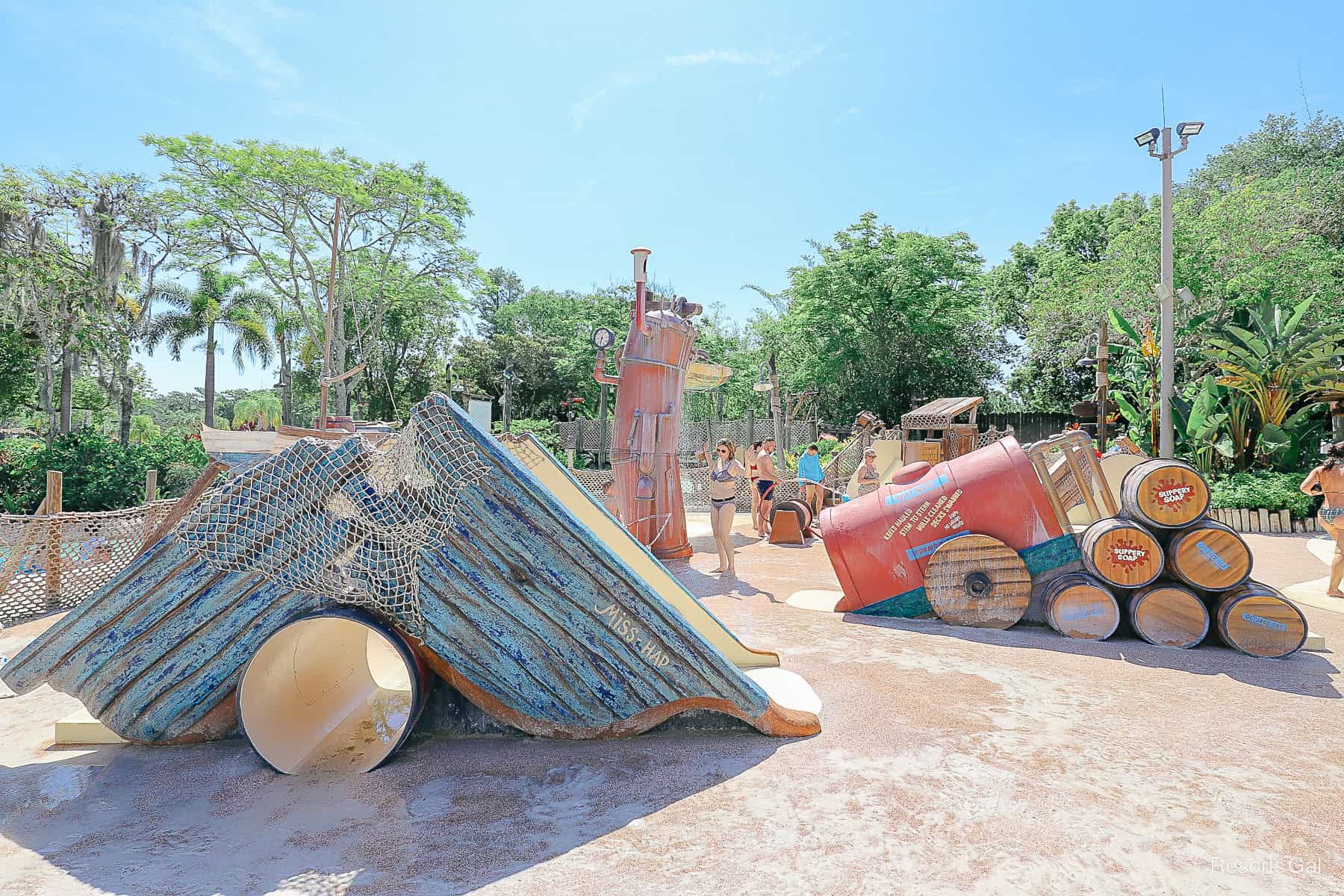 a water playground features tunnels and slides in a small splash area 