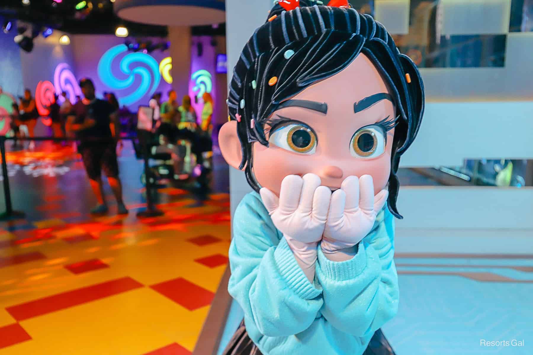 Vanellope pose with hands over mouth in a surprised expression. 