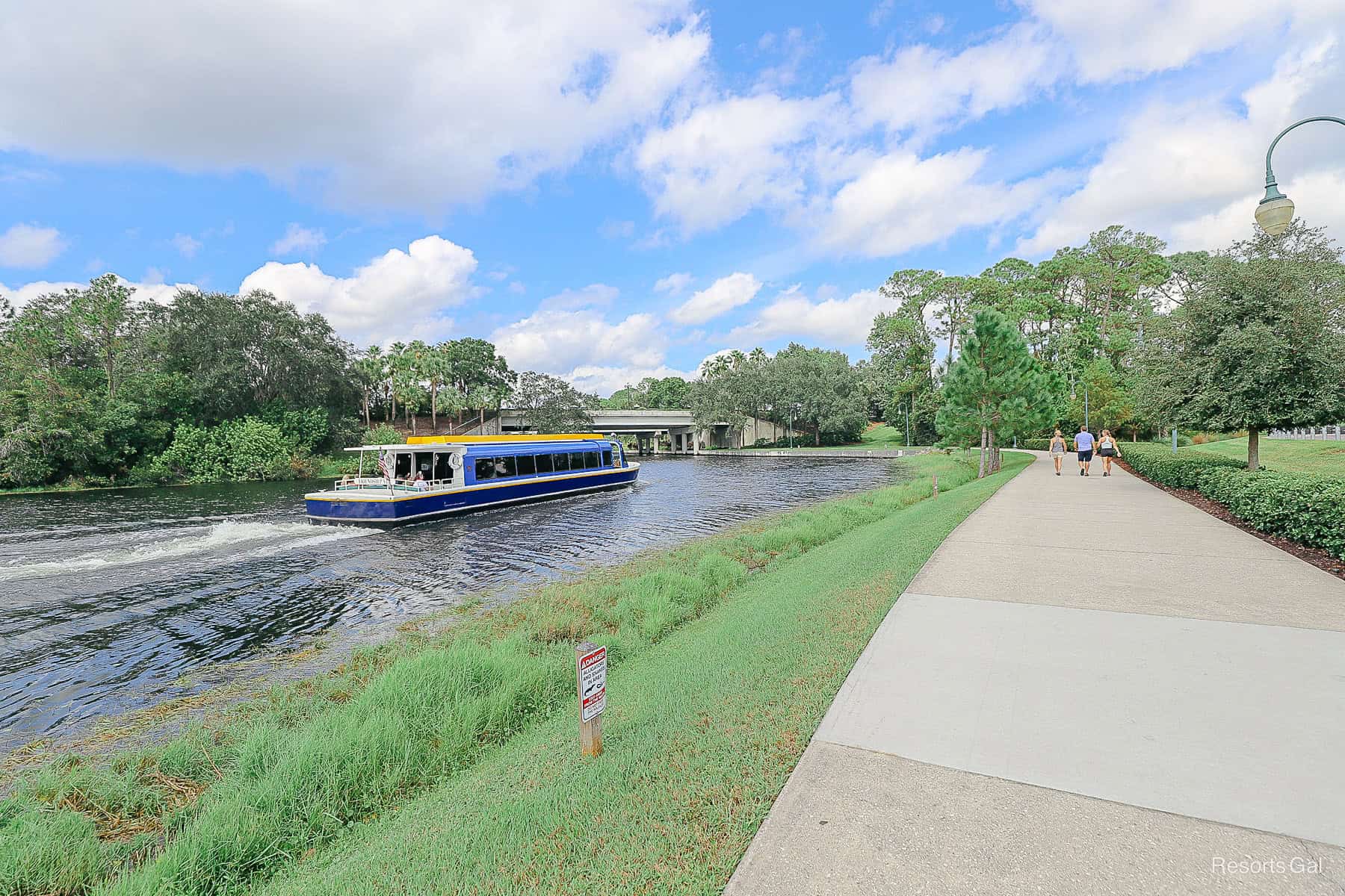 a Friendship boat that's left Hollywood Studios with guests on the walking path beside it 