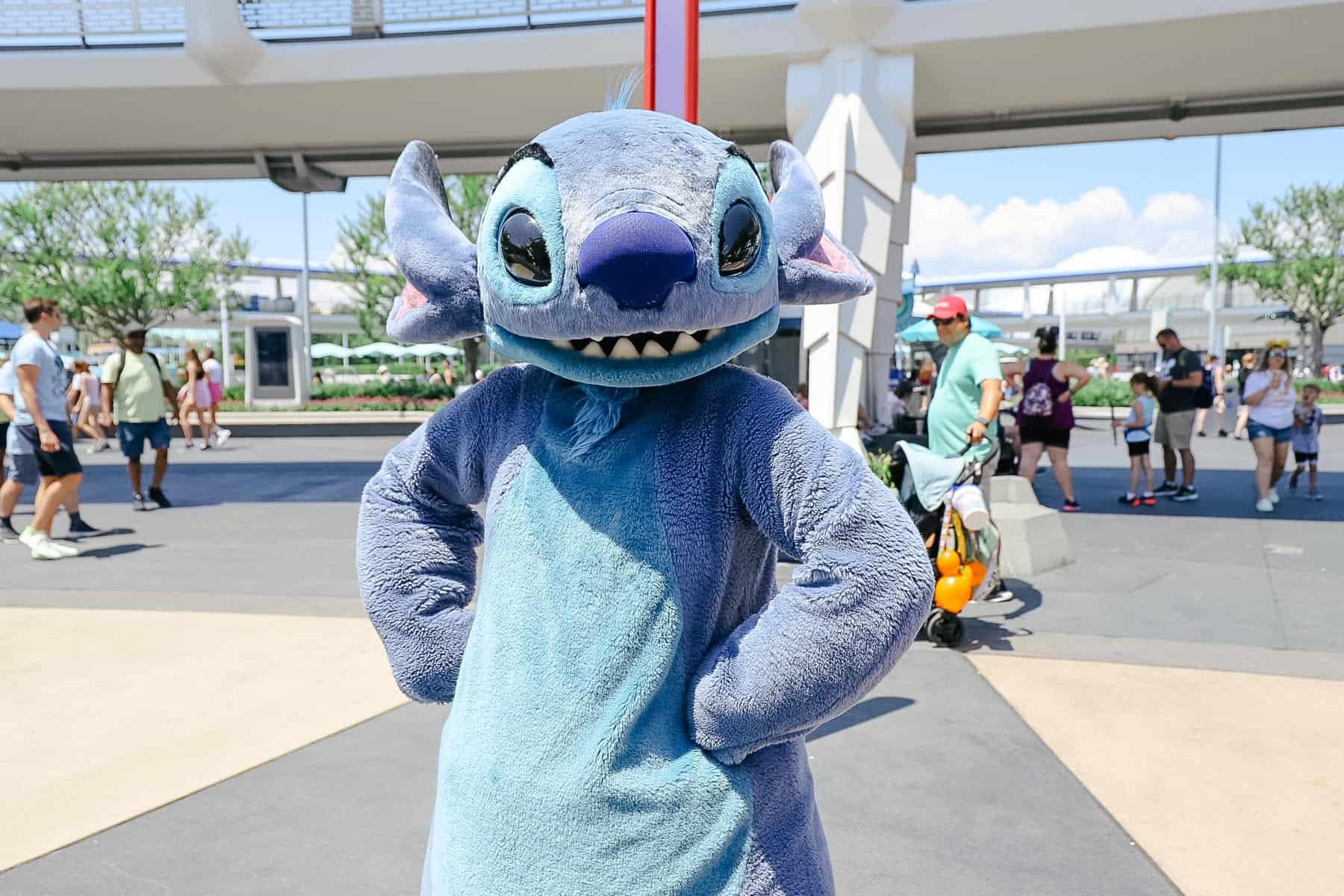 Stitch poses with his hands on his hips at Tomorrowland in Walt Disney World 