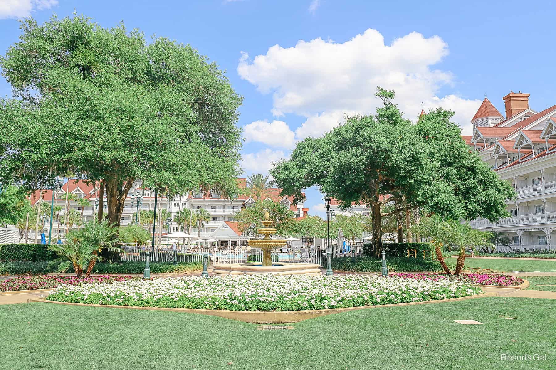 white floral beds in the Springtime surround the fountain