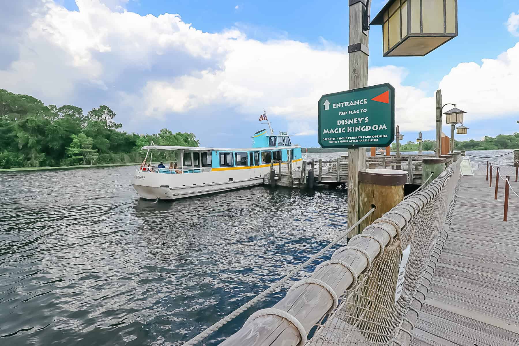 a sign that reads the entrance to the red flag to Disney's Magic Kingdom with the hours of operation for the Wilderness Lodge Boat 