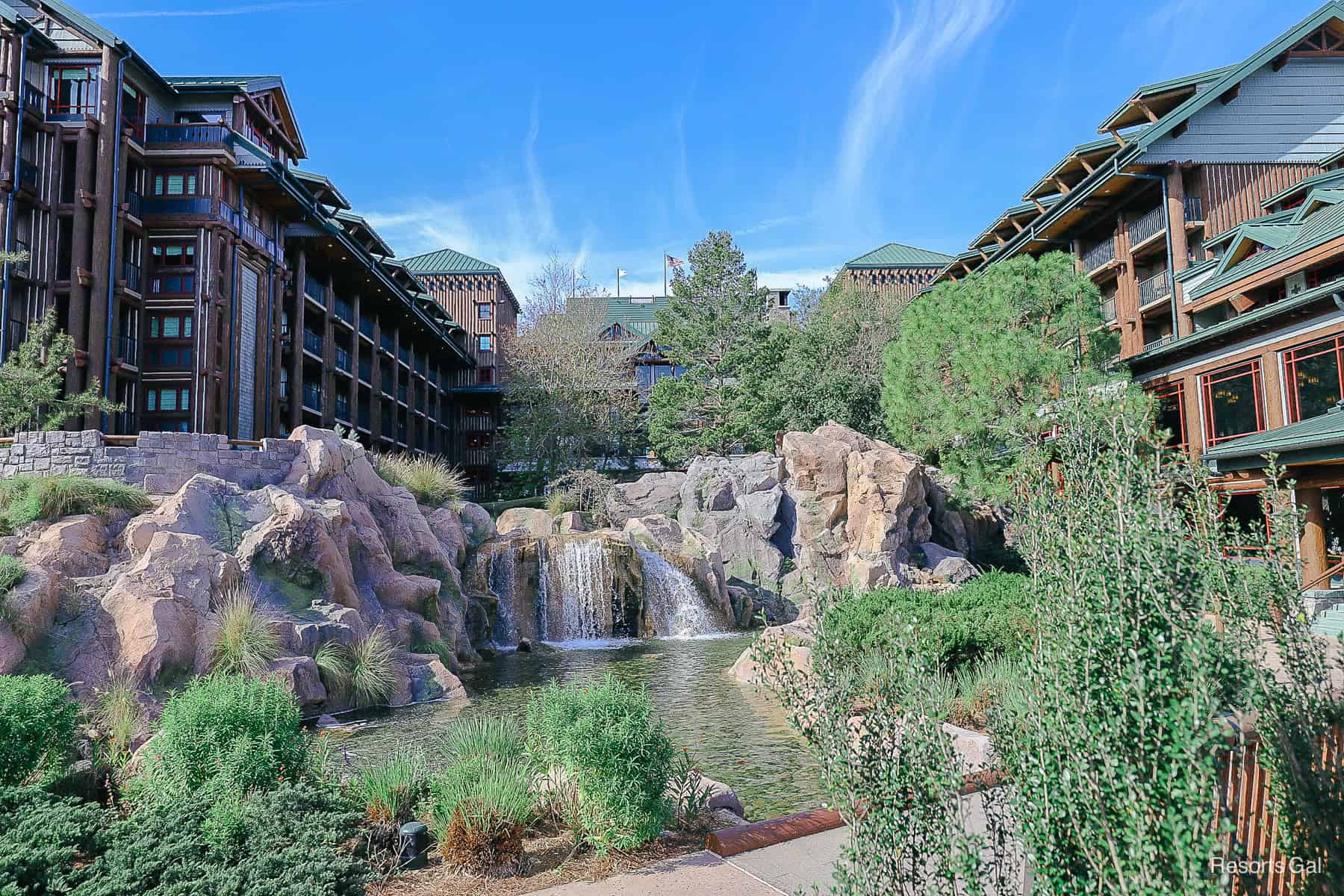 a view of the Wilderness Lodge at Disney with the waterfall feature and hotel in the backdrop 