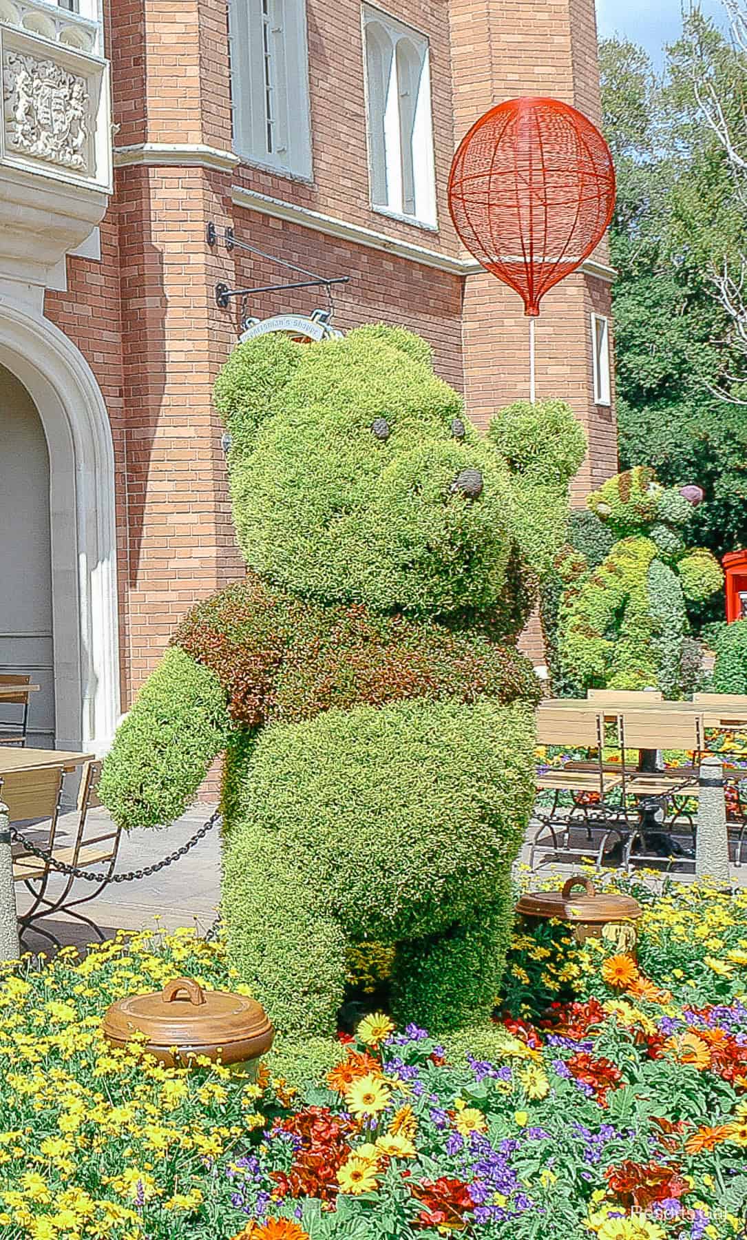 Winnie the Pooh with red shirt and balloon element in topiary form 