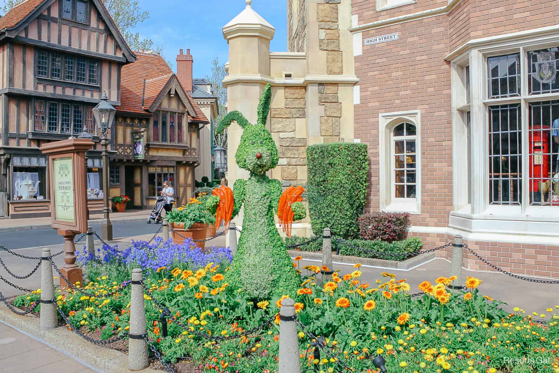 Rabbit doesn't have much of a face design and is holding carrots. He's surrounded by Gerber daisies. 