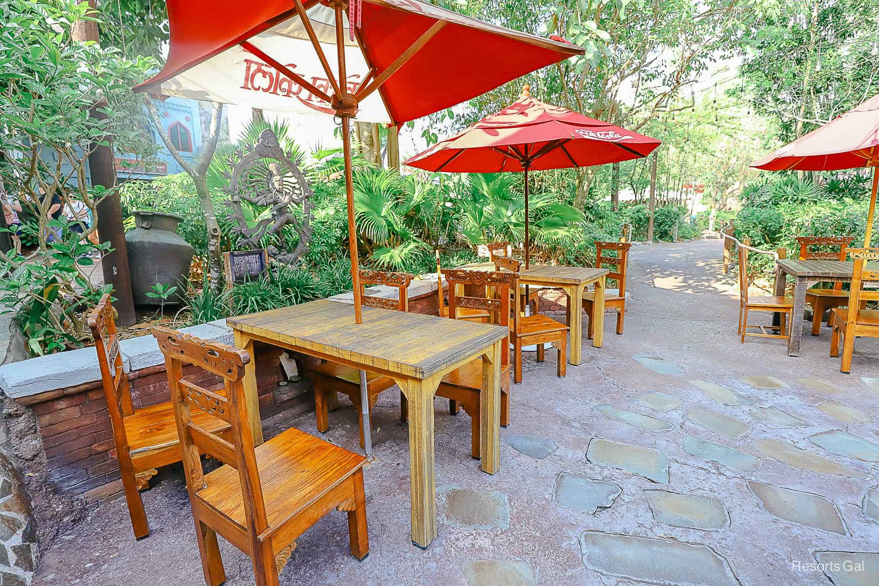 tables and chairs with umbrellas across the walkway from Yak and Yeti Local Foods Cafe