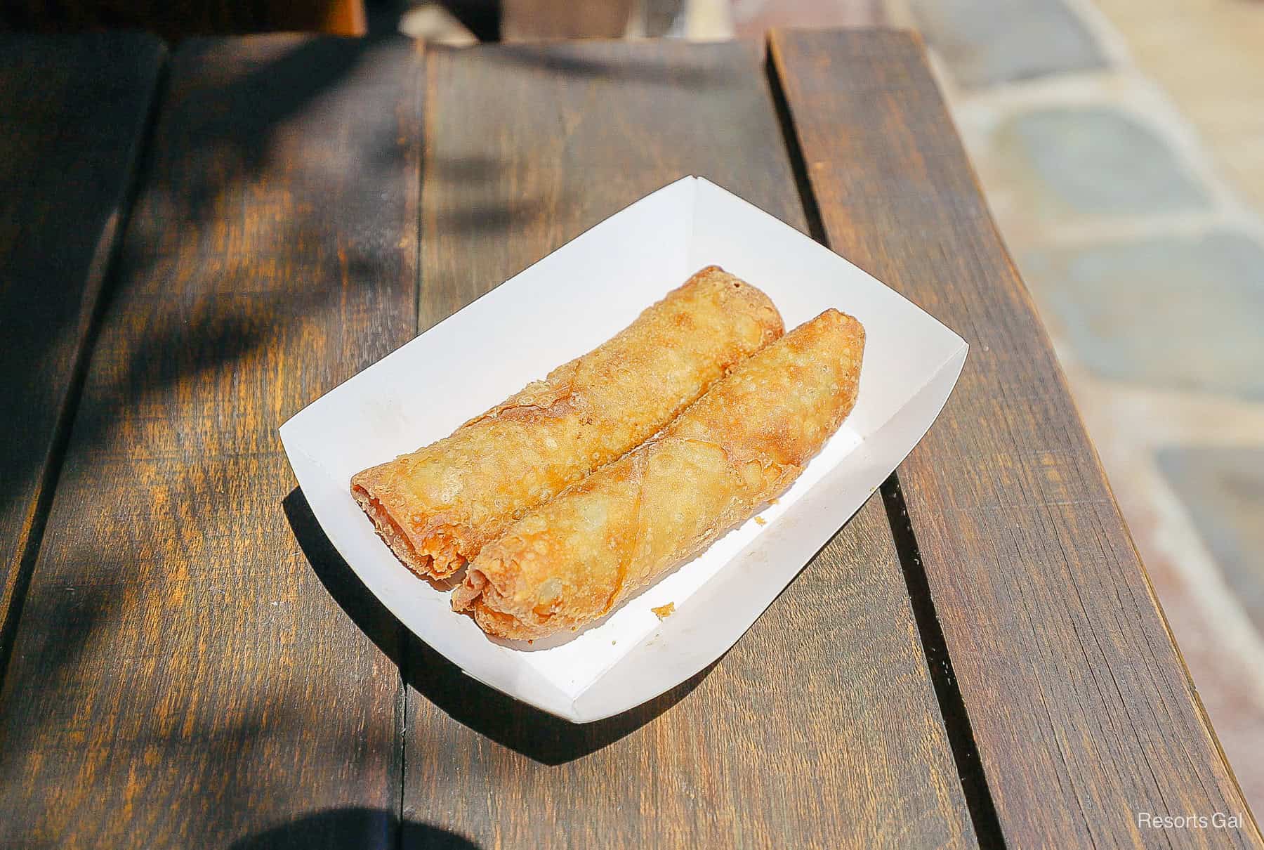 two egg rolls sitting in a white container 