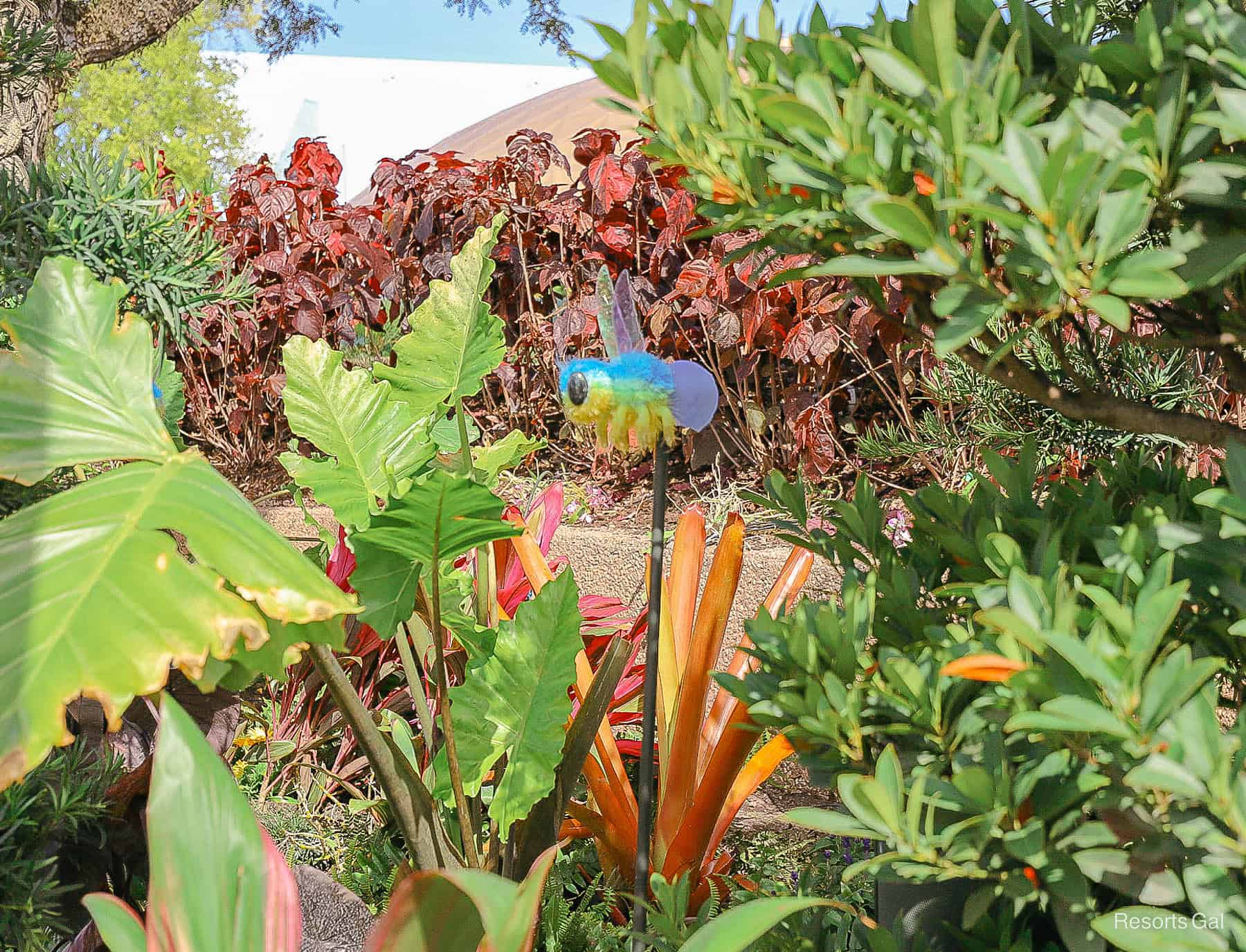 blue and yellow insect near the Groot topiary at Epcot 